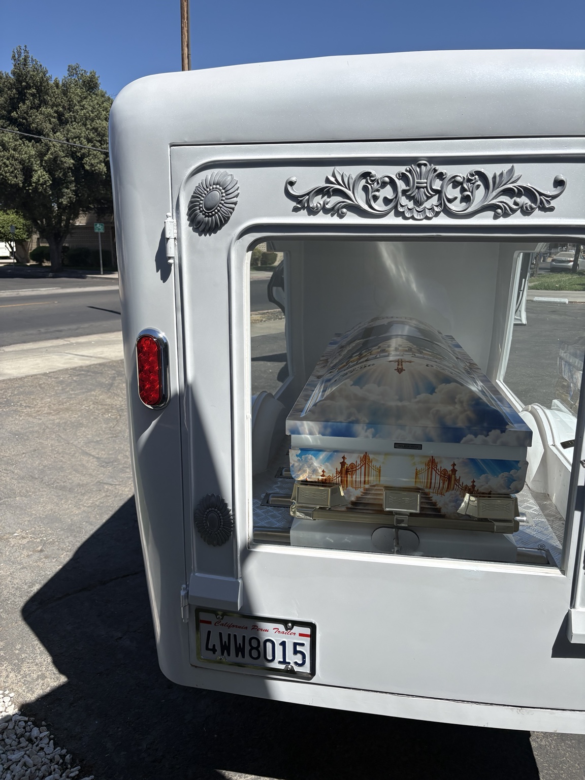 Rear view of white hearse trailer with custom casket